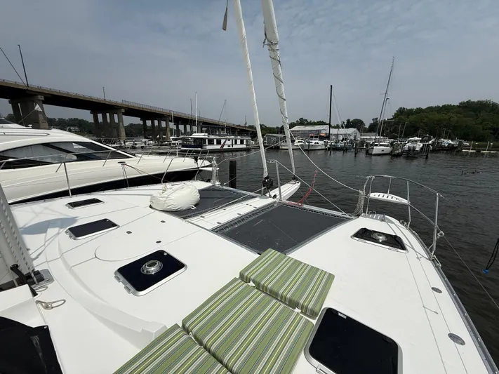 Two Fish Yacht Photos Pics Sailing yacht Antares 44GS (2021) docked at marina with striped cushions on deck.