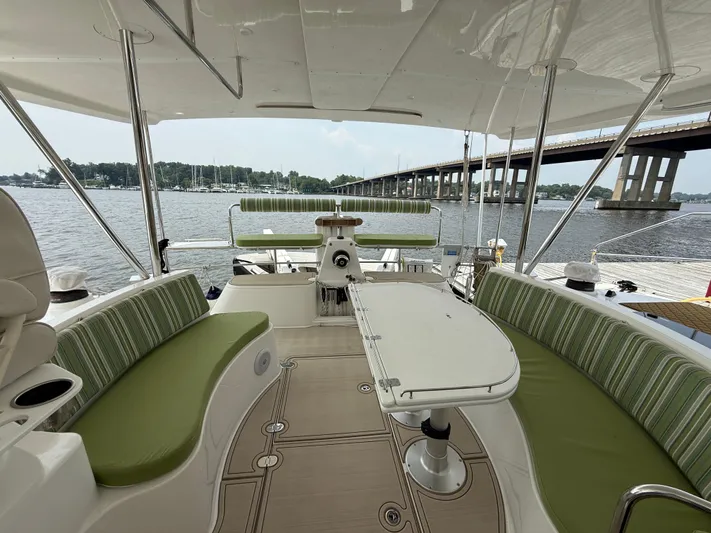 Two Fish Yacht Photos Pics 2021 Antares 44GS yacht interior with green seating, table, and water view.