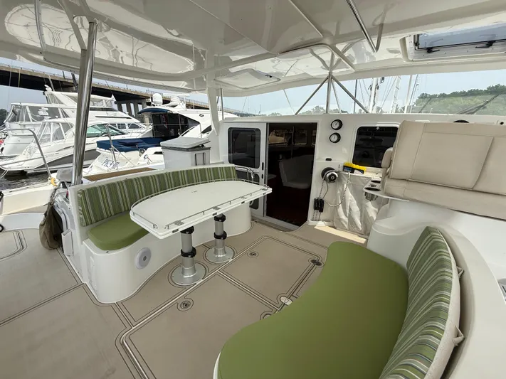 Two Fish Yacht Photos Pics Spacious 2021 Antares 44GS yacht cockpit with green seating and white table.