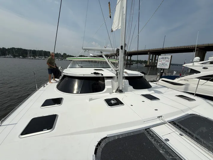 Two Fish Yacht Photos Pics 2021 Antares 44GS yacht docked by a bridge on a sunny day.