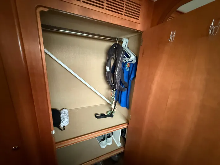 Two Fish Yacht Photos Pics Wooden closet interior on Antares 44GS 2021 yacht with clothes and shoes.