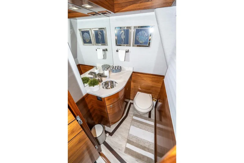 Zatara Yacht Photos Pics Luxurious bathroom in 2025 Viking 90 Convertible yacht with wood accents and nautical decor.