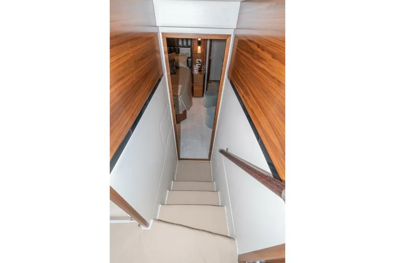 Zatara Yacht Photos Pics Stairway inside 2025 Viking 90 Convertible yacht, featuring wood paneling and modern design.