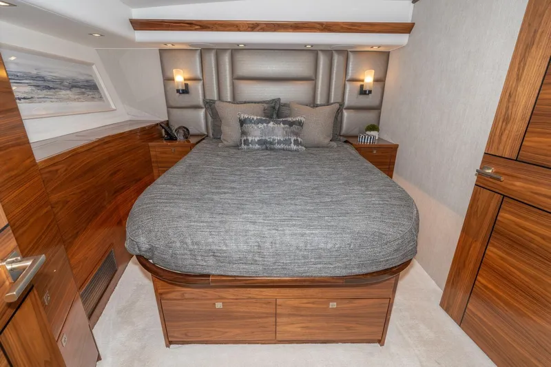 Zatara Yacht Photos Pics Luxurious bedroom interior of 2025 Viking 90 Convertible yacht with elegant wood finishes.