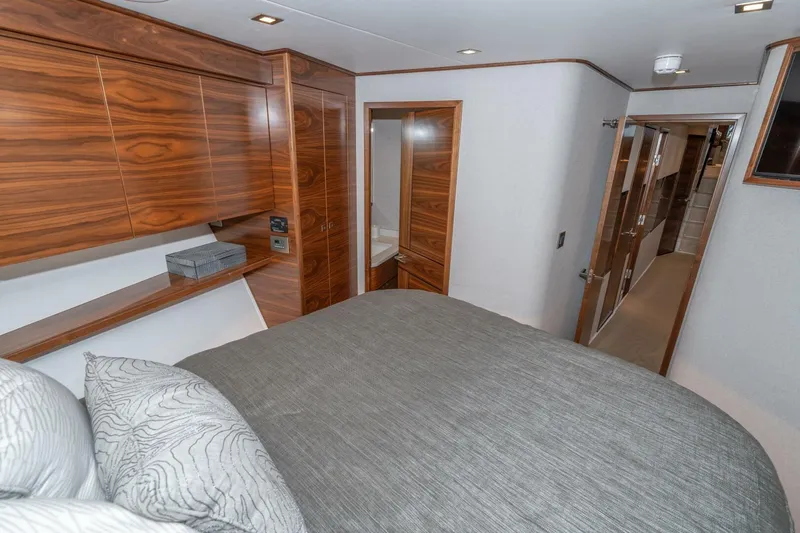 Zatara Yacht Photos Pics Luxurious bedroom interior of 2025 Viking 90 Convertible yacht with wood paneling and modern design.
