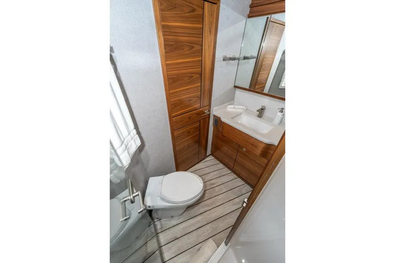 Zatara Yacht Photos Pics Luxurious bathroom in 2025 Viking 90 Convertible yacht with wood accents and modern fixtures.