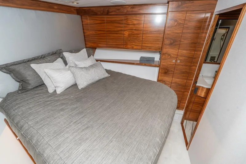 Zatara Yacht Photos Pics Luxurious bedroom interior of 2025 Viking 90 Convertible yacht with elegant wood finishes.