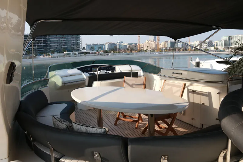 Simona Yacht Photos Pics Luxurious 2003 Azimut 98 Leonardo yacht deck with seating and table, overlooking waterfront cityscape.