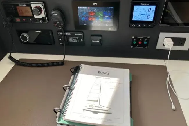 Nauti Habit Yacht Photos Pics Control panel of a 2023 Bali 4.2 yacht with navigation equipment and manual.