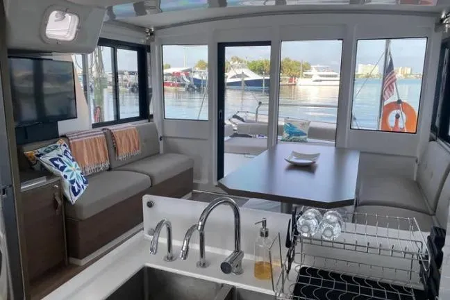 Nauti Habit Yacht Photos Pics Interior of 2023 Bali 4.2 yacht with modern seating, dining area, and waterfront view.