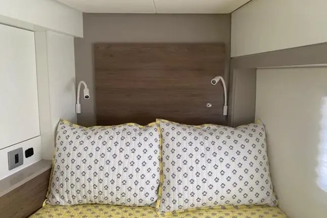 Nauti Habit Yacht Photos Pics Cozy bedroom in 2023 Bali 4.2 yacht with patterned pillows and reading lights.