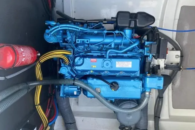 Nauti Habit Yacht Photos Pics Engine compartment of a 2023 Bali 4.2 boat, featuring a blue engine and fire extinguisher.