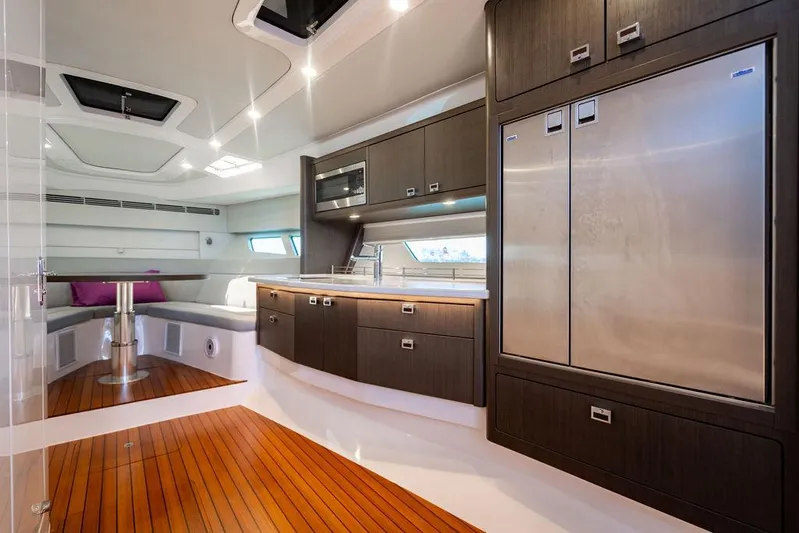  Yacht Photos Pics Luxurious interior of 2021 Intrepid 477 Evolution yacht with modern kitchen and seating area.