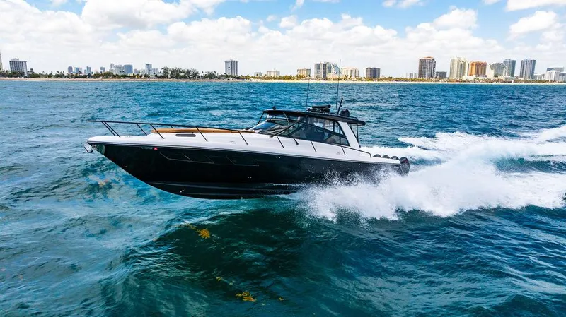  Yacht Photos Pics Intrepid 477 Evolution 2021 cruising on ocean with city skyline in background.