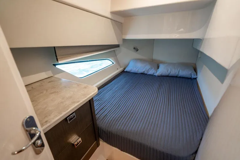  Yacht Photos Pics Cozy cabin interior of 2021 Intrepid 477 Evolution yacht with bed and window view.