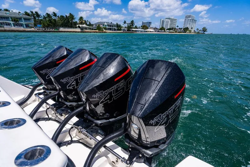  Yacht Photos Pics Four powerful outboard motors on a 2021 Intrepid 477 Evolution boat cruising in clear blue waters.