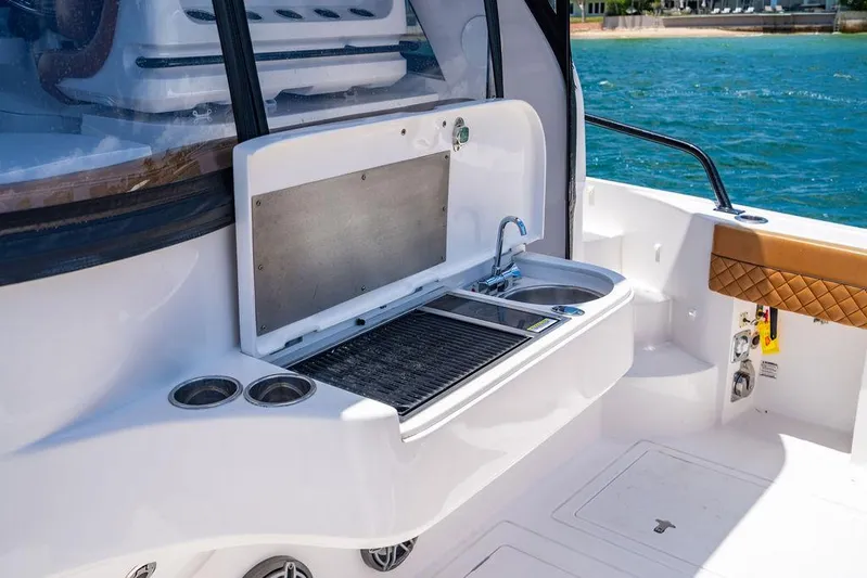  Yacht Photos Pics Outdoor kitchen on 2021 Intrepid 477 Evolution yacht with sink and grill by the water.