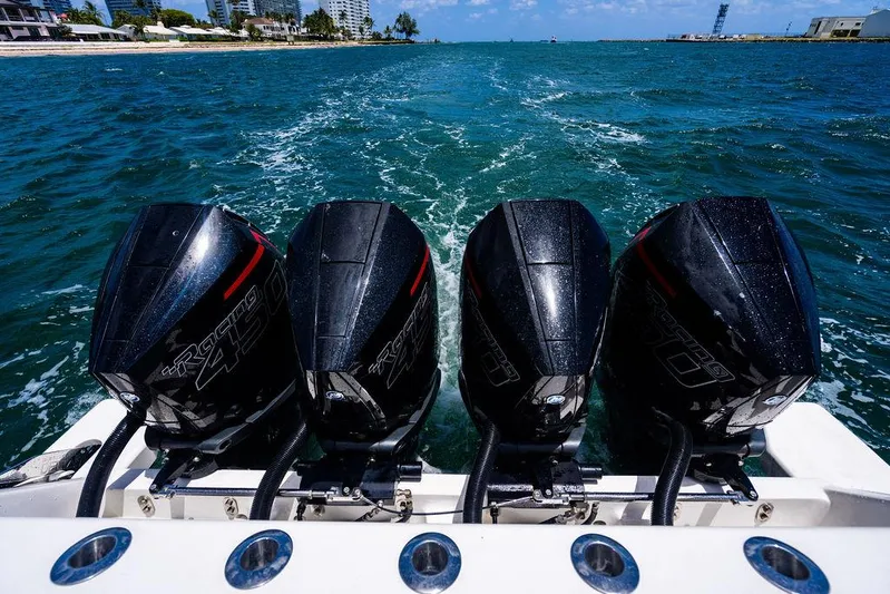  Yacht Photos Pics Four powerful outboard motors on a 2021 Intrepid 477 Evolution boat cruising through blue waters.