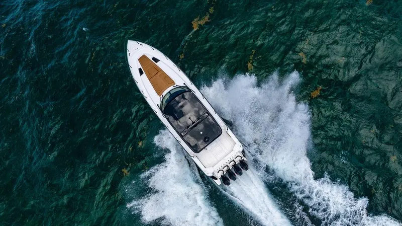  Yacht Photos Pics Aerial view of 2021 Intrepid 477 Evolution boat cruising on clear blue water.