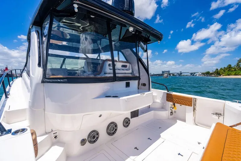  Yacht Photos Pics 2021 Intrepid 477 Evolution boat deck with seating, ocean view, and clear blue sky.