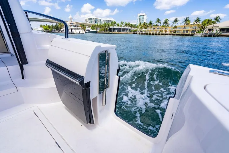  Yacht Photos Pics 2021 Intrepid 477 Evolution boat on water, open side door, scenic waterfront view.