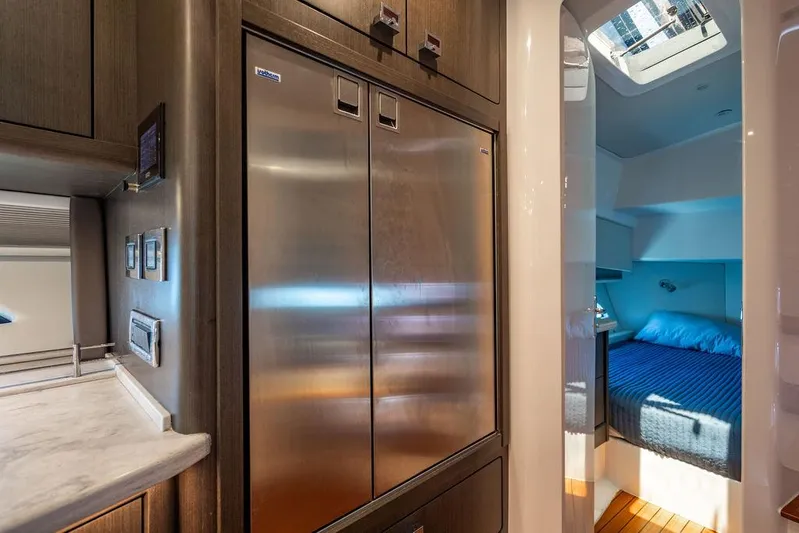  Yacht Photos Pics Luxurious interior of 2021 Intrepid 477 Evolution yacht with modern kitchen and cozy bedroom.