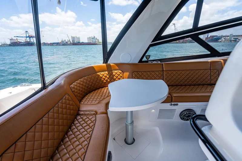 Yacht Photos Pics Luxurious 2021 Intrepid 477 Evolution yacht interior with brown leather seating and ocean view.
