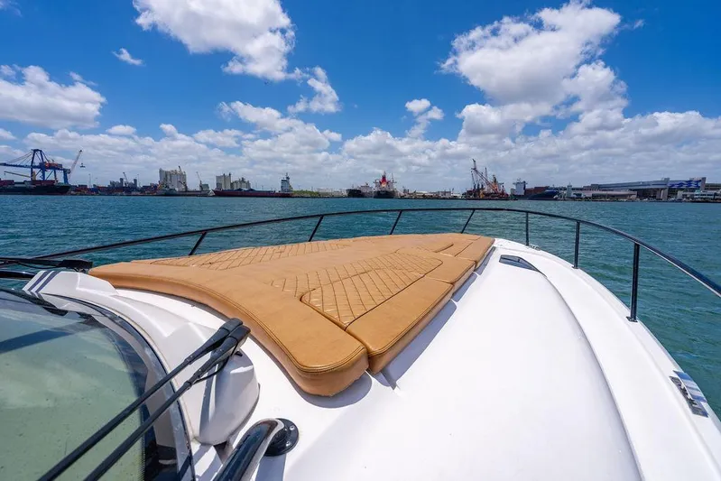  Yacht Photos Pics 2021 Intrepid 477 Evolution yacht with sun pad, cruising in a harbor under blue skies.