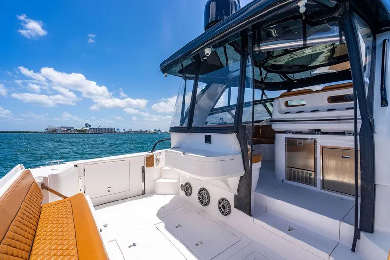  Yacht Photos Pics 2021 Intrepid 477 Evolution yacht interior with seating, ocean view, and clear blue sky.