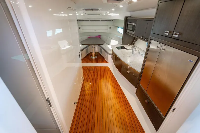  Yacht Photos Pics Luxurious interior of 2021 Intrepid 477 Evolution yacht with modern kitchen and wooden flooring.