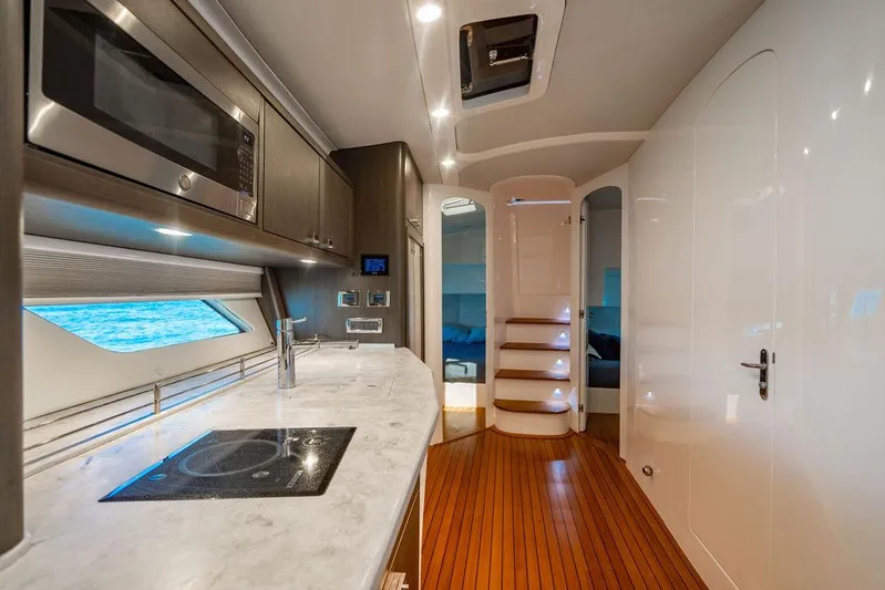  Yacht Photos Pics Luxurious interior of 2021 Intrepid 477 Evolution yacht with modern kitchen and wooden flooring.