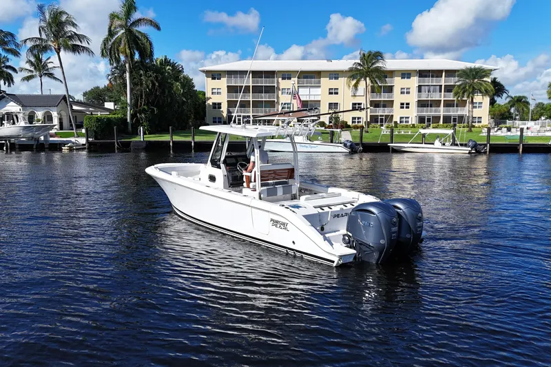  Yacht Photos Pics 2022 Pursuit S 288 Sport boat on water near waterfront homes and palm trees.
