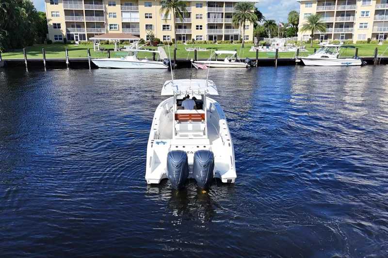  Yacht Photos Pics 2022 Pursuit S 288 Sport boat on water near waterfront buildings.