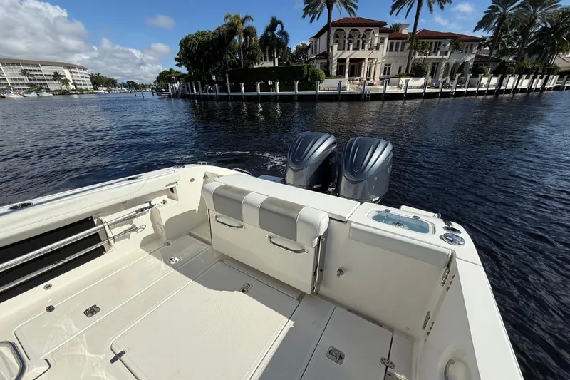  Yacht Photos Pics 2022 Pursuit S 288 Sport boat with dual engines, docked near luxury waterfront homes.