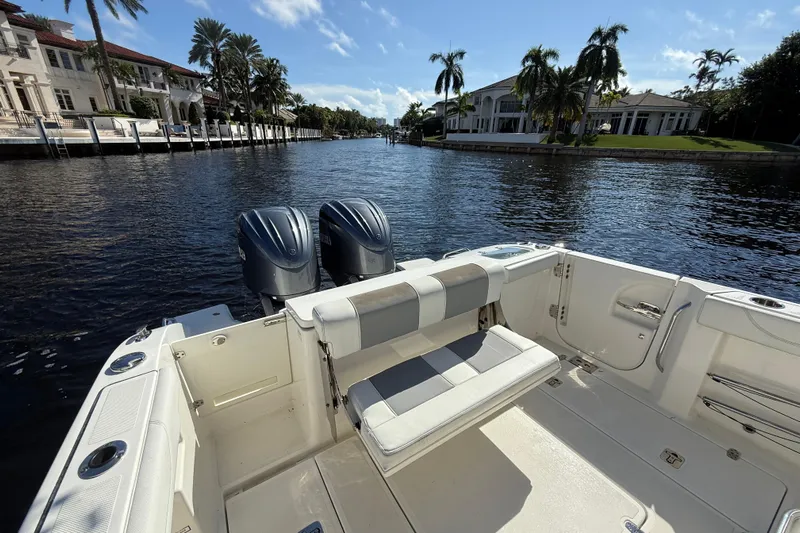  Yacht Photos Pics 2022 Pursuit S 288 Sport boat on a scenic waterfront with palm trees and luxury homes.