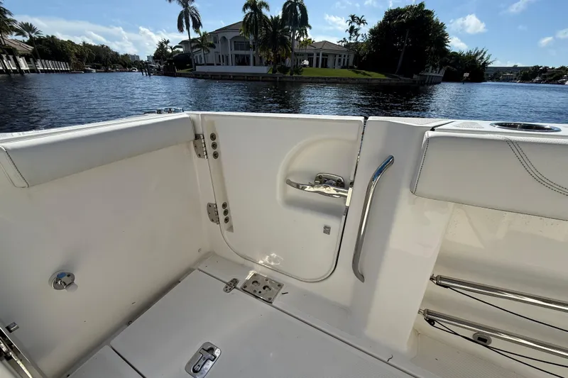  Yacht Photos Pics 2022 Pursuit S 288 Sport boat interior with open door, overlooking waterfront homes.