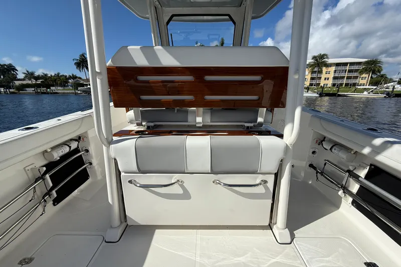  Yacht Photos Pics 2022 Pursuit S 288 Sport boat interior with seating and storage, docked by waterfront buildings.