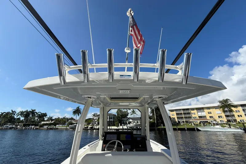  Yacht Photos Pics 2022 Pursuit S 288 Sport boat with rod holders and American flag on a sunny day.
