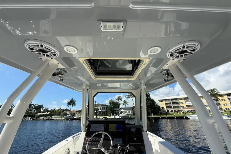  Yacht Photos Pics Interior view of 2022 Pursuit S 288 Sport boat, showcasing helm and overhead speakers.