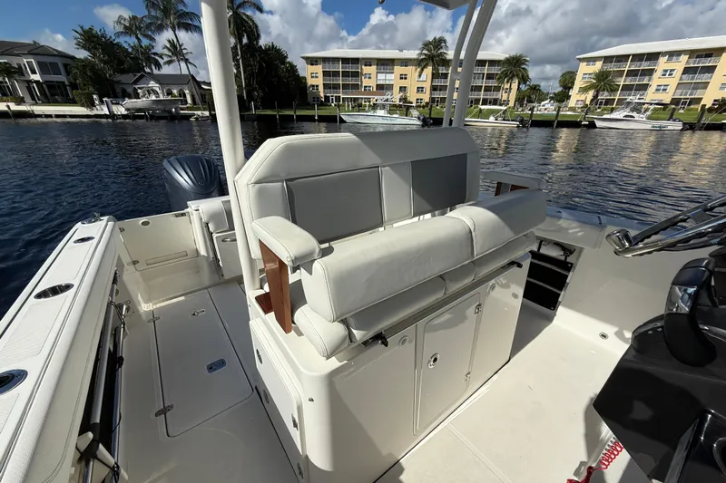  Yacht Photos Pics 2022 Pursuit S 288 Sport boat interior with seating, docked near waterfront buildings.