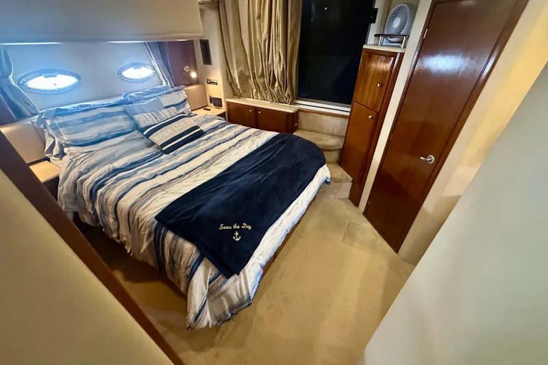  Yacht Photos Pics Luxurious bedroom in 2005 Meridian 459 Motoryacht with striped bedding and elegant wood finishes.