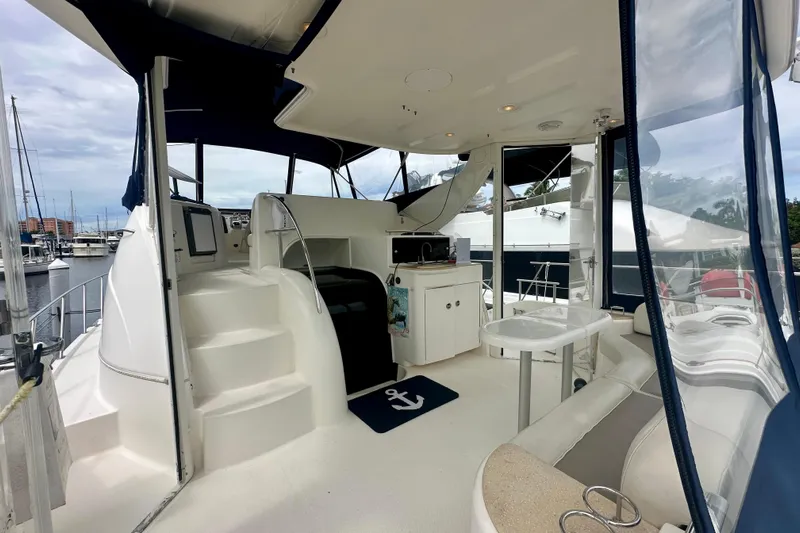  Yacht Photos Pics 2005 Meridian 459 Motoryacht interior with seating, table, and helm station in marina setting.