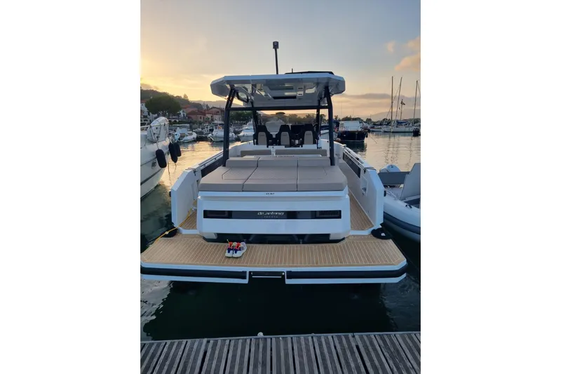  Yacht Photos Pics 2024 DE ANTONIO D32 luxury boat docked at sunset in a marina.