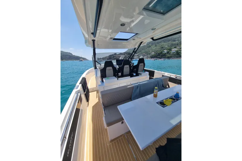  Yacht Photos Pics 2024 DE ANTONIO D32 luxury boat interior with seating and table on open water.