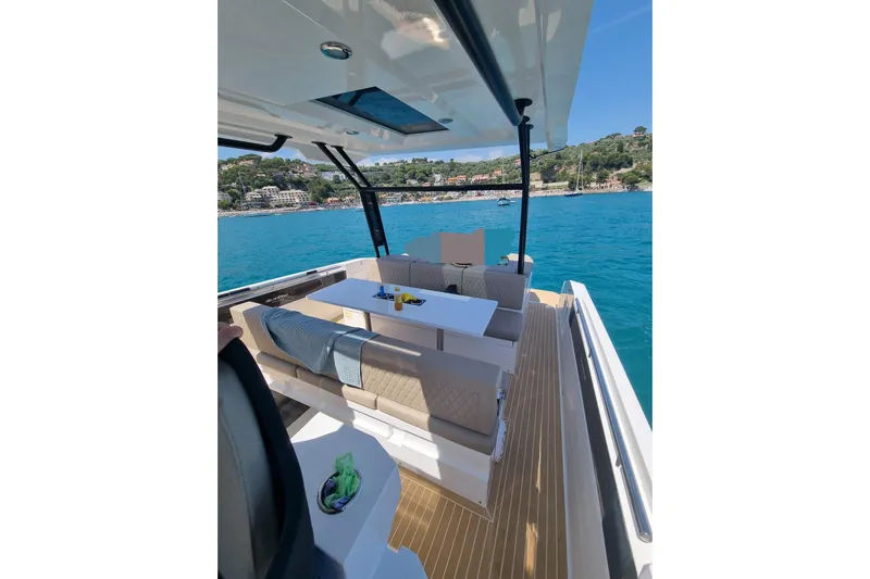  Yacht Photos Pics 2024 DE ANTONIO D32 yacht interior with seating, table, and ocean view.