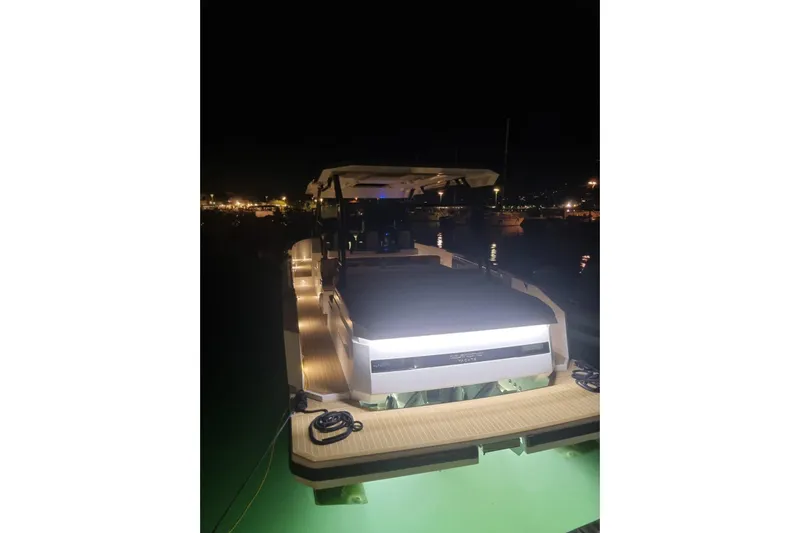  Yacht Photos Pics 2024 DE ANTONIO D32 yacht illuminated at night, docked in a marina.