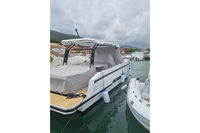  Yacht Photos Pics 2024 DE ANTONIO D32 boat docked in marina, covered and secured with fenders.