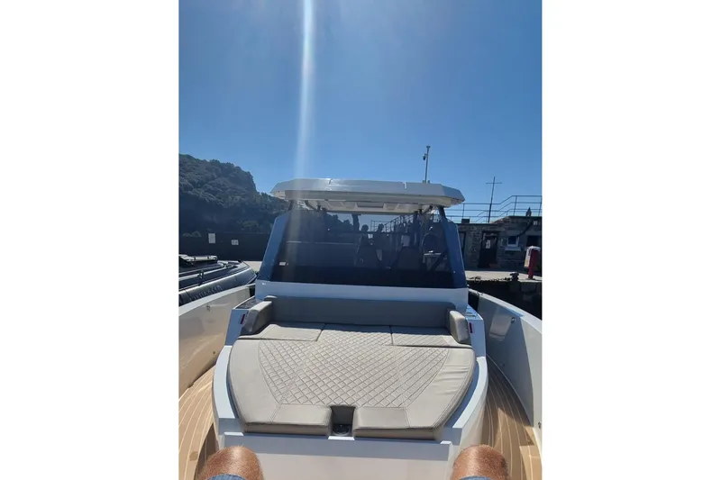  Yacht Photos Pics 2024 De Antonio Yachts D32 with sun deck, docked under clear blue sky.