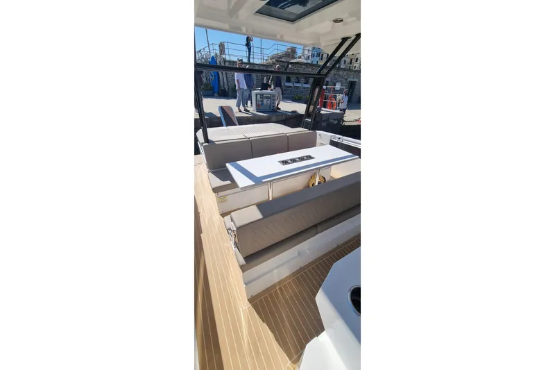  Yacht Photos Pics 2024 De Antonio Yachts D32 interior with seating and table, showcasing modern design.