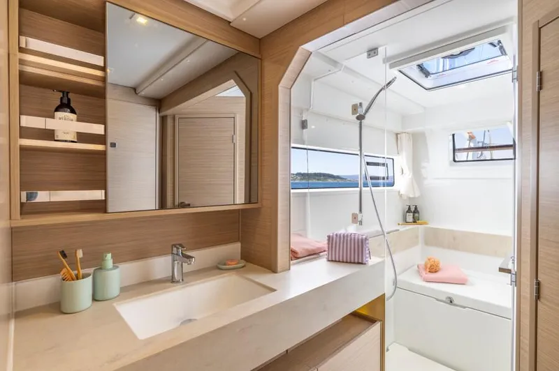  Yacht Photos Pics Luxurious bathroom interior of 2025 Lagoon 43 yacht with modern fixtures and ocean view.